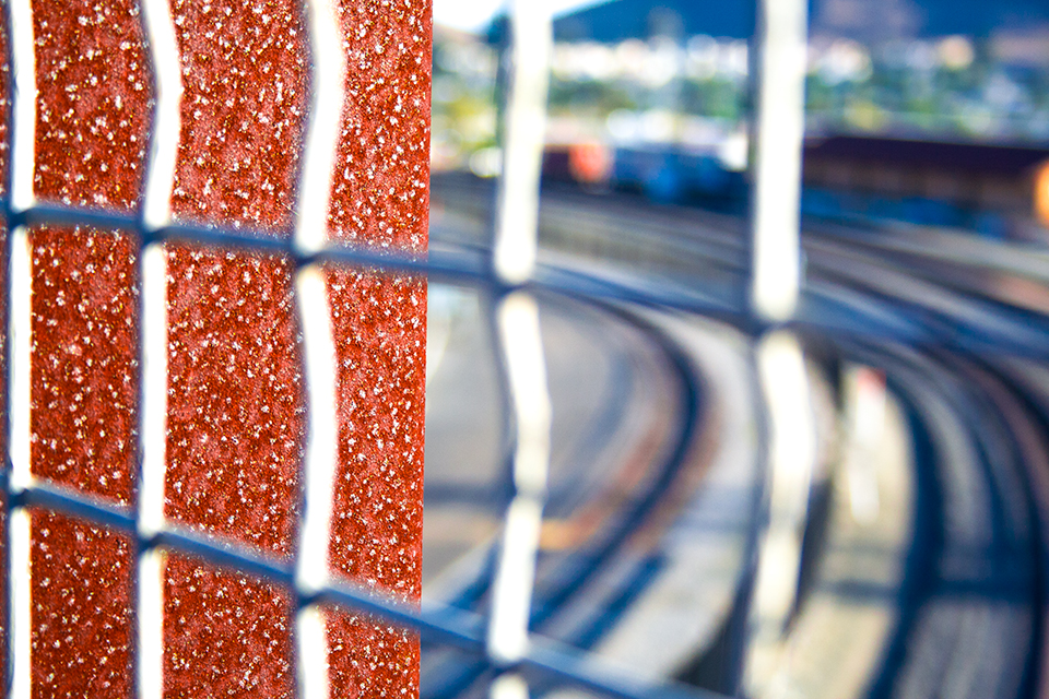 Photo of rail tracks through fence with shallow focus